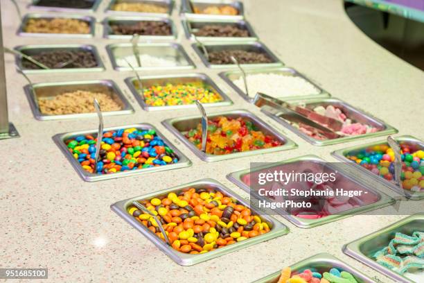 assorted toppings at frozen yogurt restaurant.candy and nuts. - toppings stock pictures, royalty-free photos & images