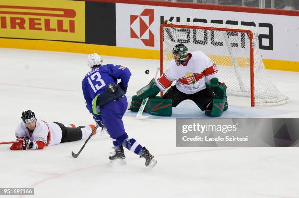 Adam Vay of Hungary watches a shot go wide from Miha Verlic of Slovenia next to Zsombor Garat of Hungary during the 2018 IIHF Ice Hockey World...