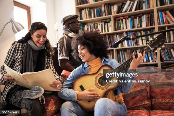 jeune femme, apprendre à jouer de la guitare avec le professeur de musique - party friends home guitar singers photos et images de collection