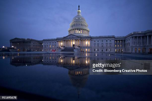 the u.s. capitol is reflected in a capitol visitor center fountain - us senate photos et images de collection