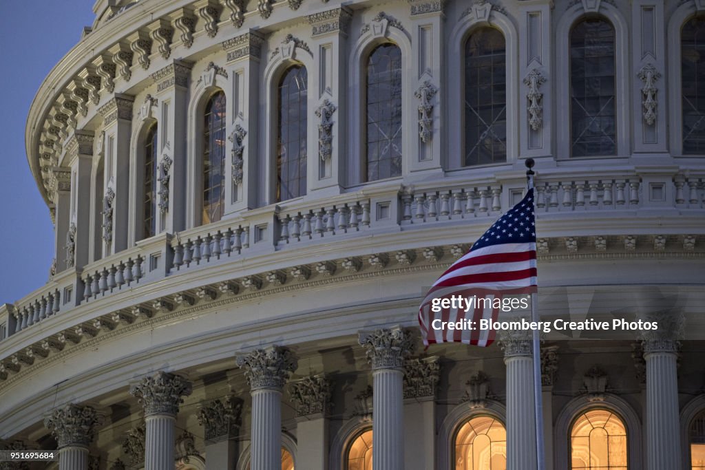 The American flag flies outside the U.S. Capitol before sunrise