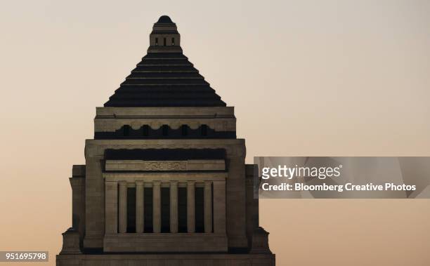 the national diet building stands illuminated at dusk in tokyo - politics and government stock pictures, royalty-free photos & images