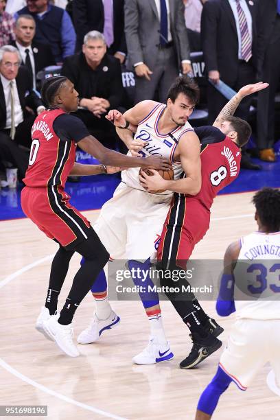 Dario Saric of the Philadelphia 76ers handles the ball against Tyler Johnson and Josh Richardson of the Miami Heat during game five of round one of...