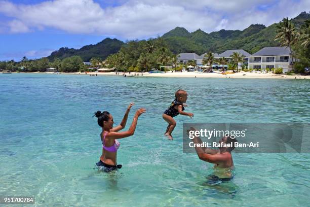 pacific islanders couple having fun with their baby boy in muri lagoon, rarotonga cook islands - rarotonga stock pictures, royalty-free photos & images