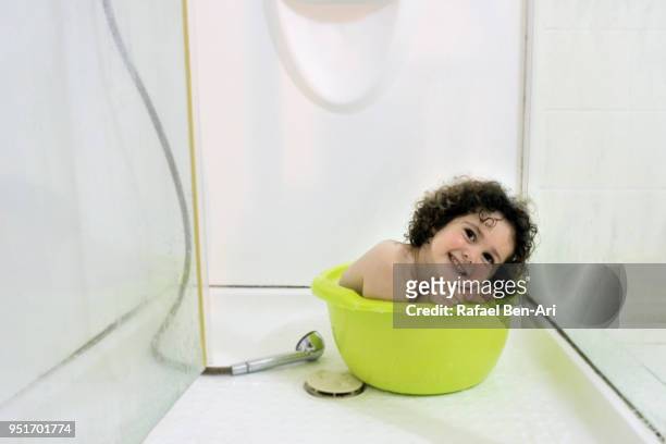 happy young girl having a bath in a bucket - rafael ben ari fotografías e imágenes de stock