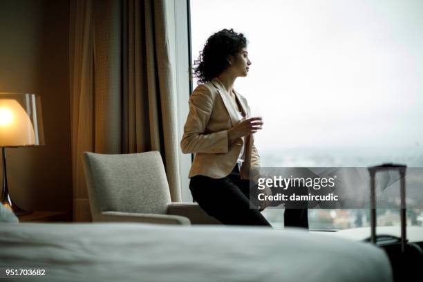 businesswoman relaxing in a hotel room - businesswoman hotel stock pictures, royalty-free photos & images