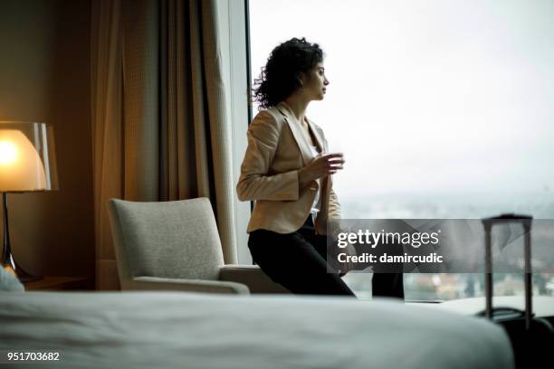businesswoman relaxing in a hotel room - quarto-de-hotel imagens e fotografias de stock