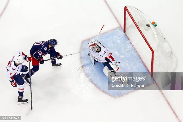 Braden Holtby of the Washington Capitals stops a shot from Alexander Wennberg of the Columbus Blue Jackets as Matt Niskanen of the Washington...