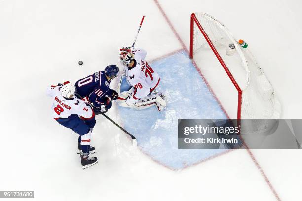 Braden Holtby of the Washington Capitals stops a shot from Alexander Wennberg of the Columbus Blue Jackets as Matt Niskanen of the Washington...