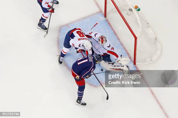 Braden Holtby of the Washington Capitals stops a shot as Chandler Stephenson of the Washington Capitals attempts to clear the puck past Matt Calvert...