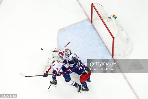 Braden Holtby of the Washington Capitals makes a save as Matt Niskanen of the Washington Capitals attempts to keep Nick Foligno of the Columbus Blue...