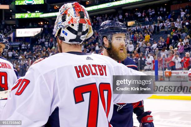 Braden Holtby of the Washington Capitals shakes hands with David Savard of the Columbus Blue Jackets at the end of Game Six of the Eastern Conference...