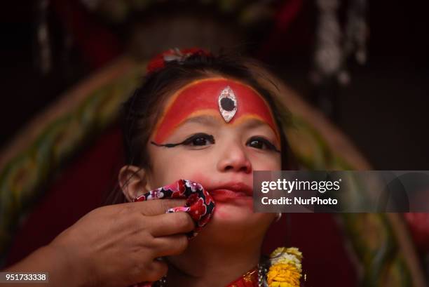 Family member cleans face of 5 yrs old Living goddess of Patan, Nihira Bajracharya, arrive to observe the Chariot Pulling Festival of Rato...