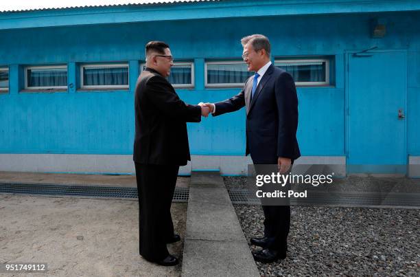 North Korean Leader Kim Jong Un and South Korean President Moon Jae-in shake hands over the military demarcation line upon meeting for the...