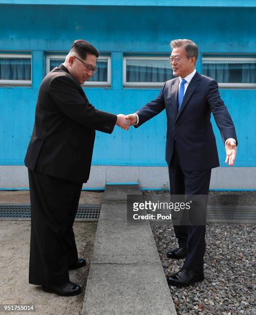 North Korean Leader Kim Jong Un and South Korean President Moon Jae-in shake hands over the military demarcation line upon meeting for the...