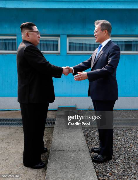 North Korean Leader Kim Jong Un and South Korean President Moon Jae-in shake hands over the military demarcation line upon meeting for the...