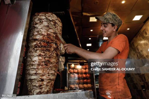 General view taken on April 26 shows a man preparing Shawarma in the northern Syrian enclave of Afrin that Ankara-backed forces captured from Kurdish...