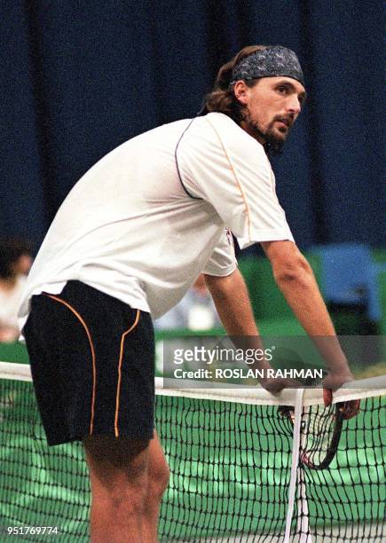 Second seeded Croatian Goran Ivanisevic looks disappointed as he holds onto the net during a match with Australian Mark Woodforde in the 700,000 USD...