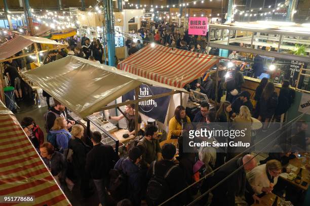 Visitors walk among food stalls at the weekly Street Food Thursday at Markthalle Neun in Kreuzberg district on April 26, 2018 in Berlin, Germany....
