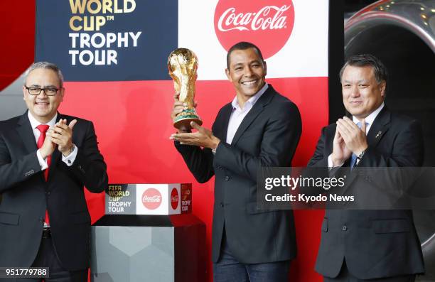 Former Brazil national football team defender Gilberto Silva , alongside Japan Football Association President Kozo Tashima , poses with the FIFA...