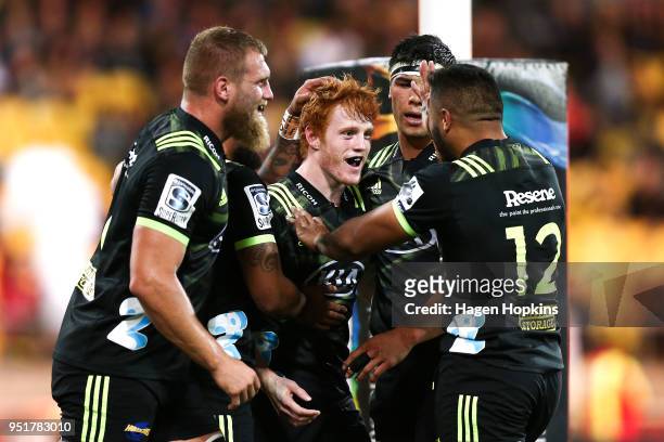 Finlay Christie of the Hurricanes celebrates with Matt Proctor, Brad Shields, Vince Aso and Reed Prinsep after scoring a try on debut during the...