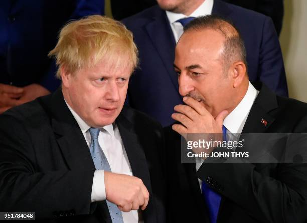 British Foreign Secretary Boris Johnson talks with Turkey Foreign Affairs Minister Mevlut Cavusoglu as they pose for a family photo during a Foreign...