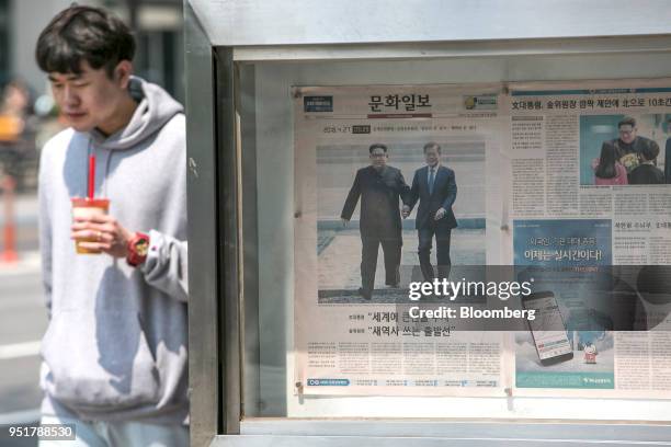 Copy of Munhwa Ilbo newspaper, featuring photographs of Moon Jae-in, South Korea's President, right, and Kim Jong Un, North Korea's leader walking...