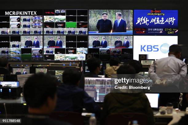 Members of the media watch multiple screens, showing a broadcast of Moon Jae-in, South Korea's president, right, and Kim Jong Un, North Korea's...