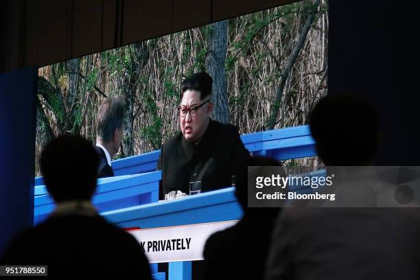 Members of the media watch a screen, showing a broadcast of Moon Jae-in, South Korea's president, left, and Kim Jong Un, North Korea's leader,...