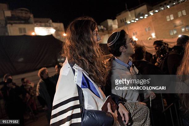 Jewish woman wears a prayer shawl, worn customarily by men only, at the end of a prayer service at the Western Wall Plaza held by the "Women at the...