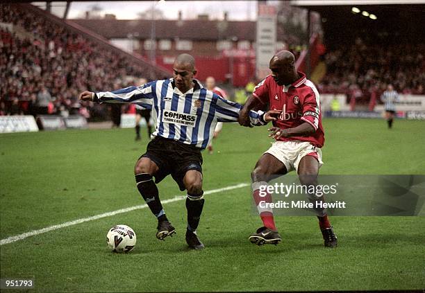 Junior McDougald of Dagenham and Redbridge holds off Richard Rufus of Charlton Athletic during the AXA sponsored FA Cup match played at The Valley in...