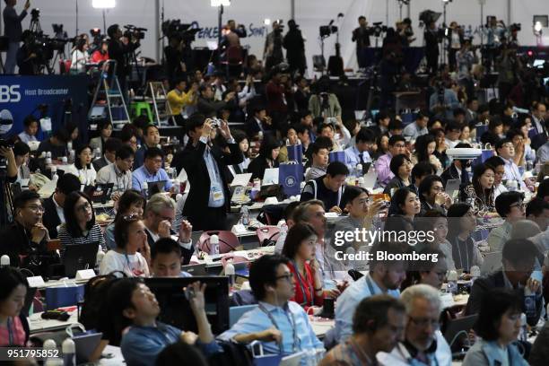 Members of the media watch a screen, showing a broadcast of Moon Jae-in, South Korea's president, and Kim Jong Un, North Korea's leader, not...