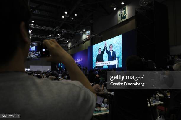 Members of the media watch a screen, showing a broadcast of Moon Jae-in, South Korea's president, right, and Kim Jong Un, North Korea's leader in the...