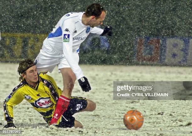 Le milieu de terrain de l'AJ Auxerre Yann Lachuer déborde le milieu de terrain suisse de Sochaux Johann Lonfat, le 01 février 2003 sur la pelouse du...