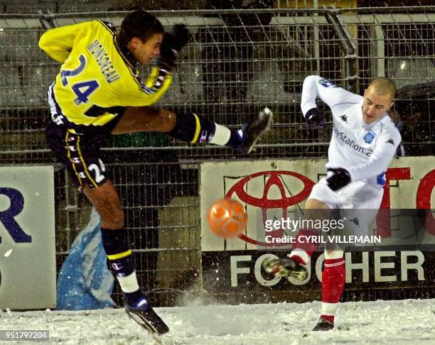 Le milieu de terrain de l'AJ Auxerre Lionel Mathis est à la lutte avec le défenseur de Sochaux Sylvain Monsoreau, le 01 février 2003 sur la pelouse...