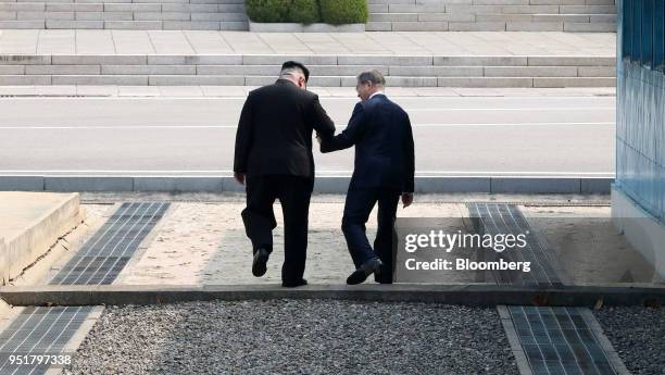 Kim Jong Un, North Korea's leader, left, and Moon Jae-in, South Korea's president, hold hands as they cross the Military Demarcation Line to the...