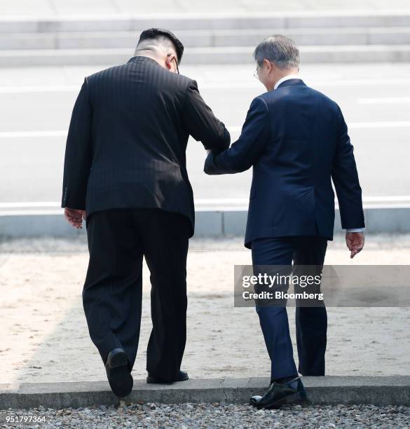 Kim Jong Un, North Korea's leader, left, and Moon Jae-in, South Korea's president, hold hands as they cross the Military Demarcation Line to the...