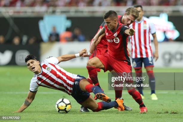 Alan Pulido of Chivas fights for the ball with Auro Junior of Toronto FC during the second leg match of the final between Chivas and Toronto FC as...