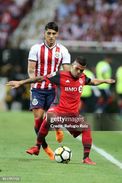 Alan Pulido of Chivas fights for the ball with Auro Junior of Toronto FC during the second leg match of the final between Chivas and Toronto FC as...