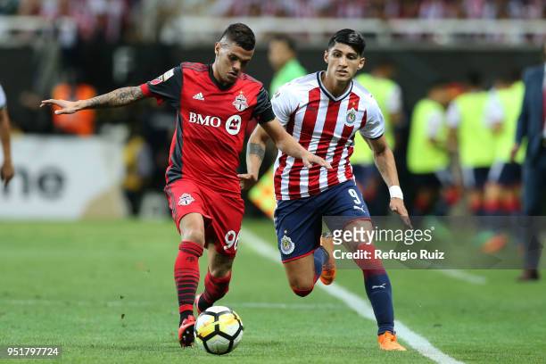 Alan Pulido of Chivas fights for the ball with Auro Junior of Toronto FC during the second leg match of the final between Chivas and Toronto FC as...