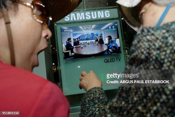 Woman reacts while watching a screen showing news coverage of the inter-Korean summit meeting between South Korean President Moon Jae-in and North...