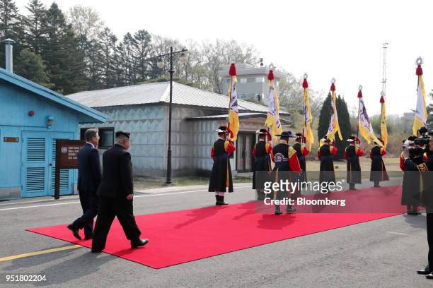 Moon Jae-in, South Korea's president, left, and Kim Jong Un, North Korea's leader, walk along a red carpet together in the village of Panmunjom in...