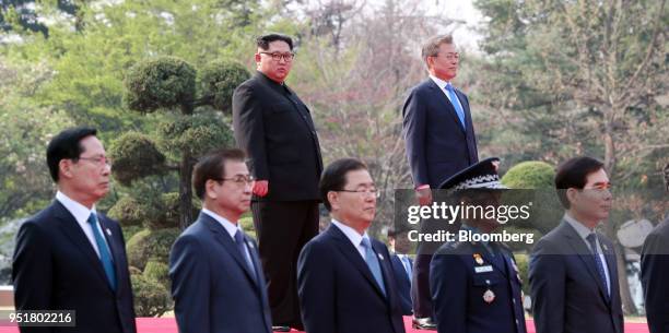 Kim Jong Un, North Korea's leader, center left, and Moon Jae-in, South Korea's president, stand on a podium during an honor guard ceremony in the...