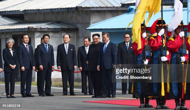 Kim Jong Un, North Korea's leader, center left, and Moon Jae-in, South Korea's president, stand together during an honor guard ceremony in the...