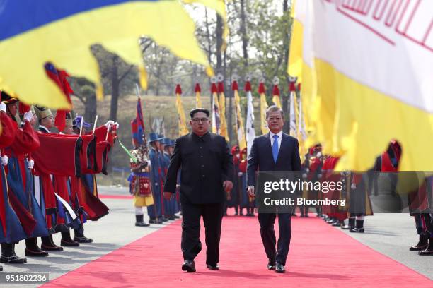 Kim Jong Un, North Korea's leader, center left, and Moon Jae-in, South Korea's president, walk along a red carpet together during an honor guard...