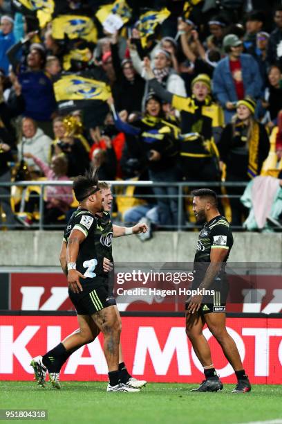 Vince Aso of the Hurricanes celebrates with Ardie Savea and James O'Reilly after scoring a try during the round 11 Super Rugby match between the...