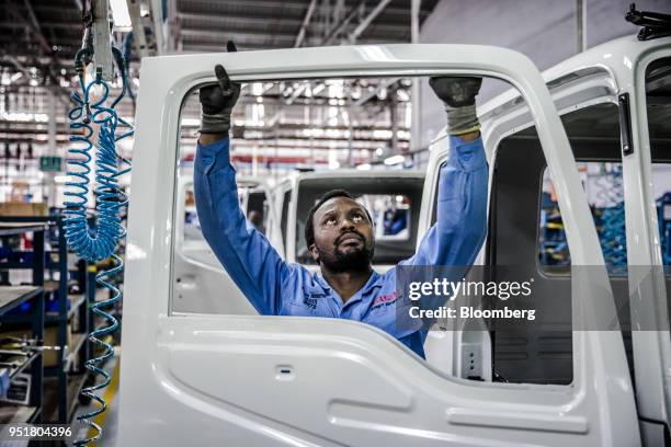 An employee inspects the interior door panel of an Isuzu FSR 33H F-Series truck on the assembly line inside the Isuzu East Africa Ltd. Plant in...