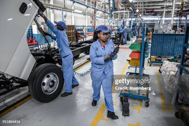 Employees work under the cabin of an Isuzu NPR N-Series Truck on the assembly line inside the Isuzu East Africa Ltd. Plant in Nairobi, Kenya, on...