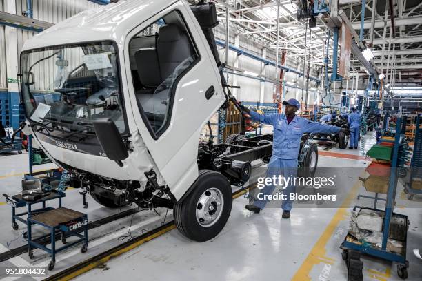 An employee controls a hoist to lift the cabin of an Isuzu NPR N-Series Truck on the assembly line inside the Isuzu East Africa Ltd. Plant in...