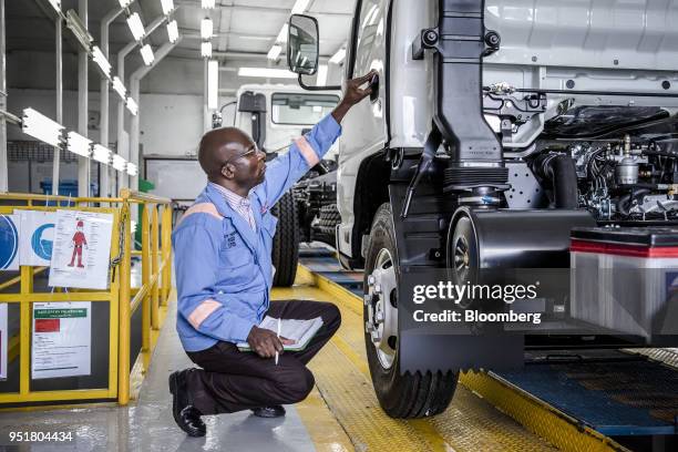 An employee checks the door handle of an Isuzu NPR N-Series truck on the quality control line inside the Isuzu East Africa Ltd. Plant in Nairobi,...